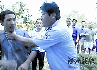 一村民欲阻止拆遷，被一個身穿監察大隊制服的工作人員掐住脖子，野蠻推開