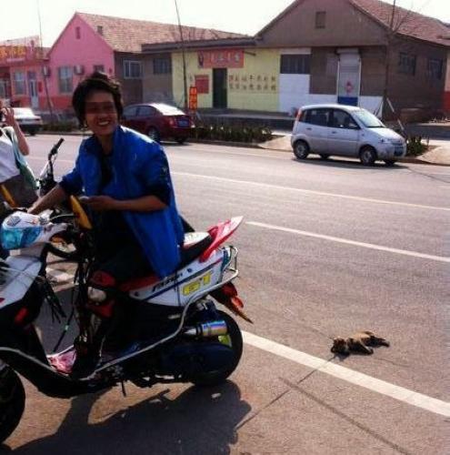 男子騎摩托車虐狗