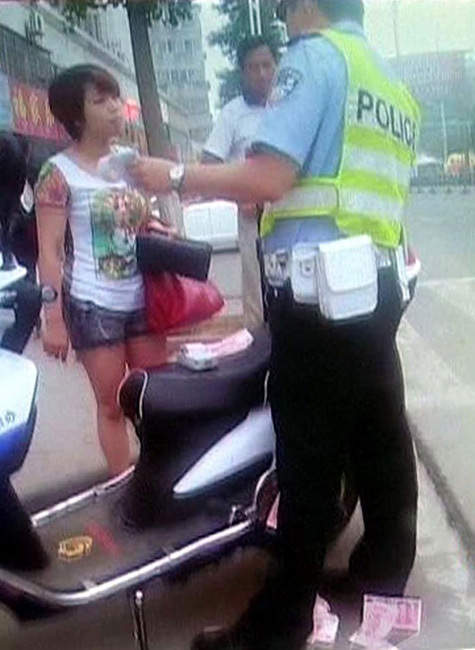 女車(chē)主鈔票扔交警羞辱人 市民看不下去報(bào)警