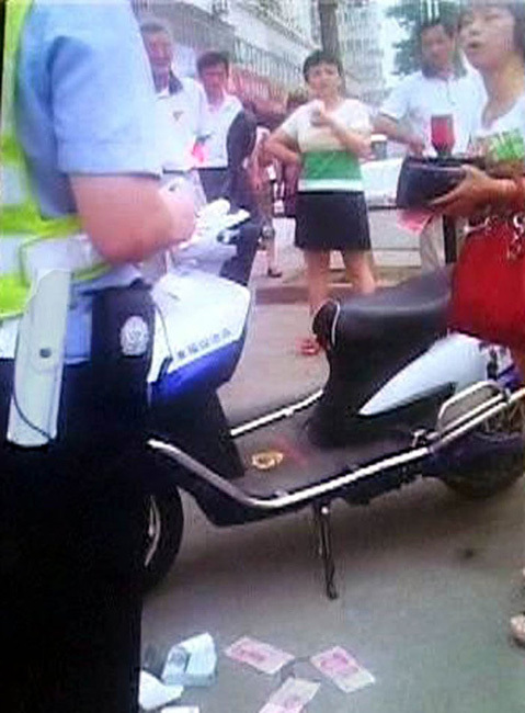 女車(chē)主鈔票扔交警羞辱人 市民看不下去報(bào)警