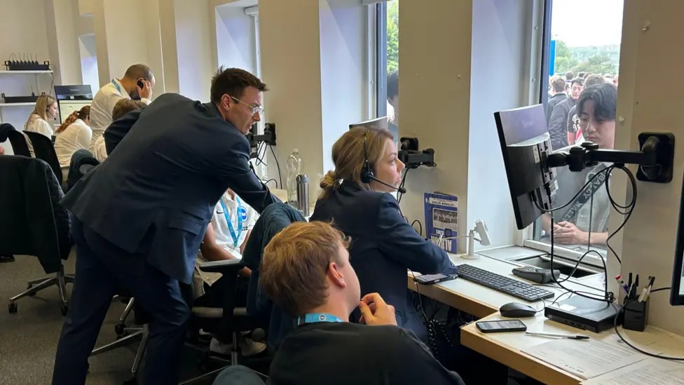 工作人員坐在美國(guó)運(yùn)通體育場(chǎng)布萊頓售票處回答球迷們關(guān)于門(mén)票的問(wèn)題